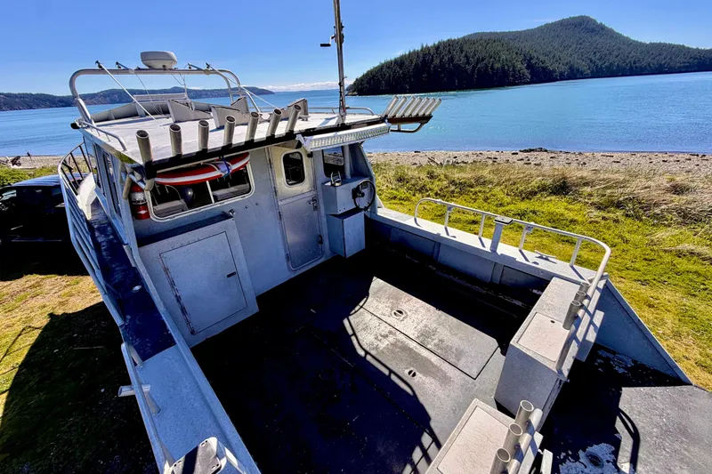 Slide: The Image of 2001 Maxweld Maxcat boat on shore with scenic lake and forested hills in background. - 11