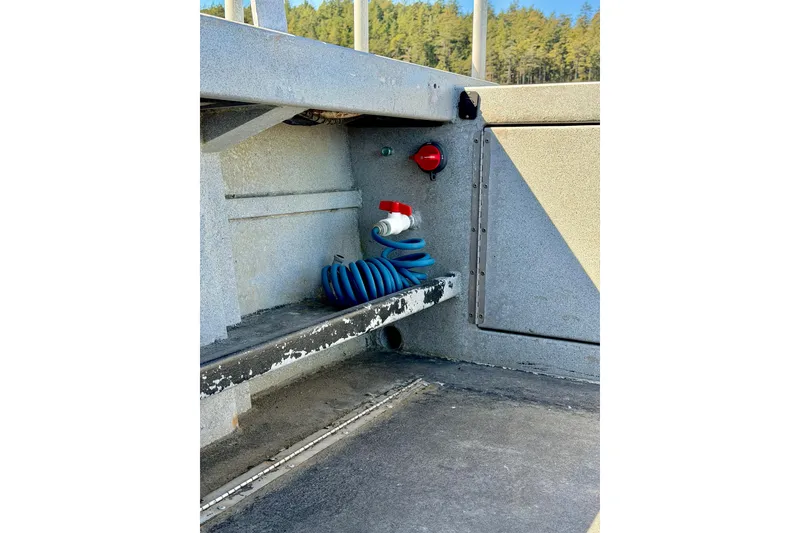 Slide: The Image of Interior of a 2001 Maxweld Maxcat boat showing coiled blue hose and red valve. - 15