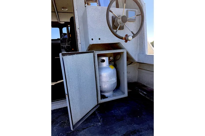 Slide: The Image of Steering wheel and propane tank compartment on 2001 Maxweld Maxcat boat. - 16