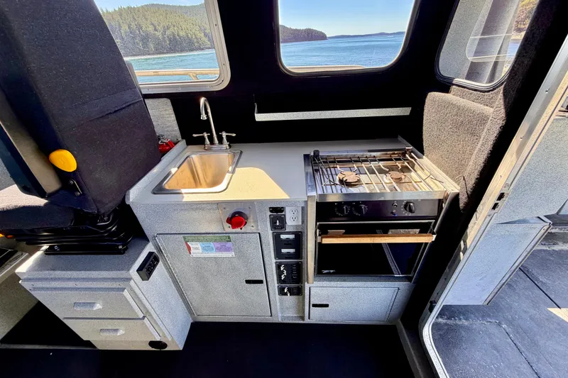 Slide: The Image of Compact kitchen area in a 2001 Maxweld Maxcat boat with sink and stove. - 19