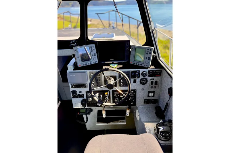 Slide: The Image of Cockpit of a 2001 Maxweld Maxcat boat with steering wheel and navigation equipment. - 24