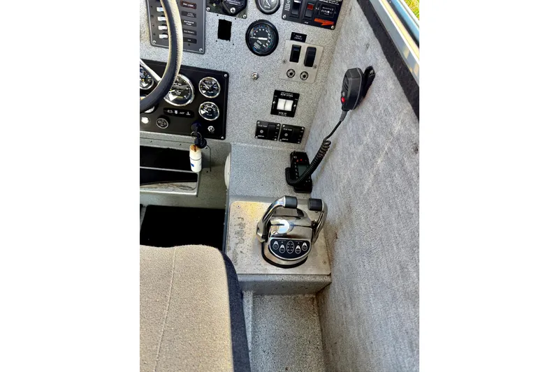 Slide: The Image of Control panel of a 2001 Maxweld Maxcat boat with steering wheel and communication device. - 28