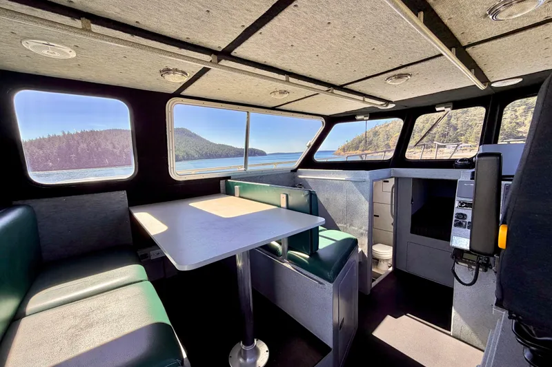 Slide: The Image of Interior of 2001 Maxweld Maxcat boat with table, seating, and scenic window views. - 31