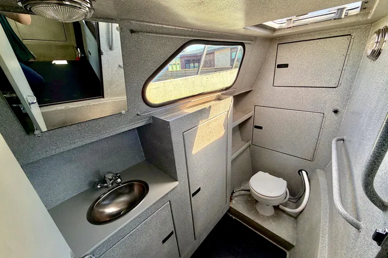 Slide: The Image of Compact boat bathroom with sink, toilet, and storage in a 2001 Maxweld Maxcat. - 35
