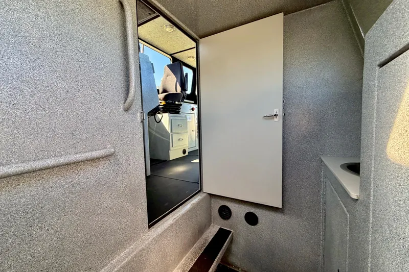 Slide: The Image of Interior of a 2001 Maxweld Maxcat boat, featuring a cabin with seating and storage. - 36