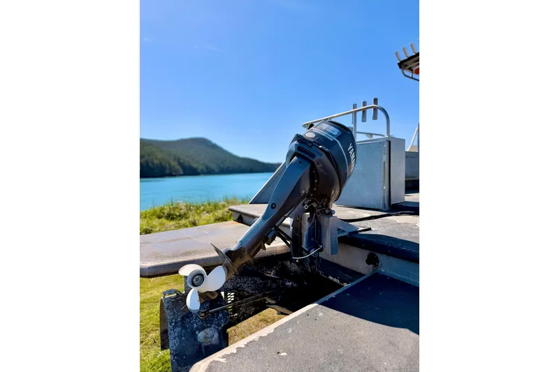 Slide: The Image of Outboard motor on a 2001 Maxweld Maxcat boat by a scenic lake. - 6