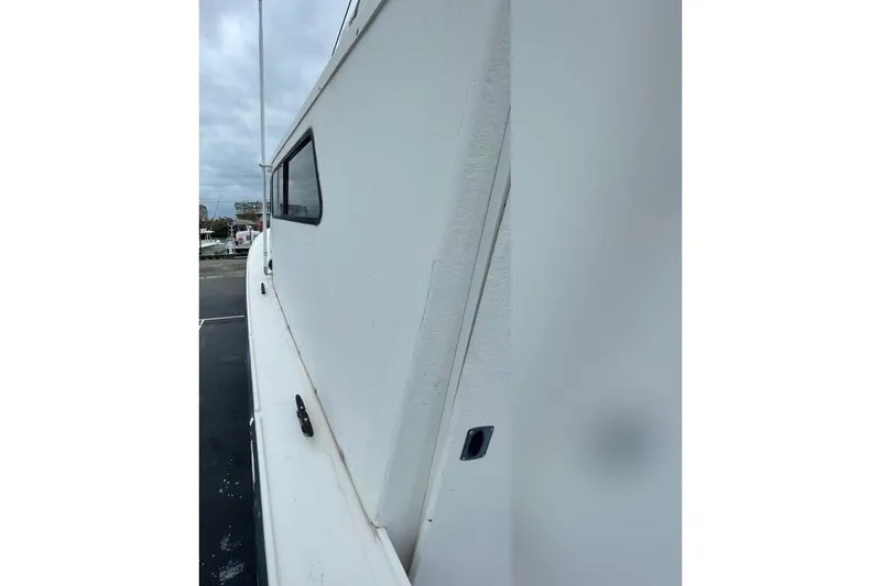 Slide: The Image of 1977 JC 31 Casco Bay boat side view with window, docked outdoors. - 11