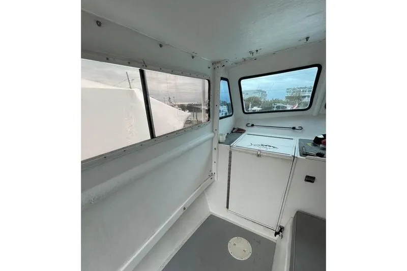 Slide: The Image of Interior of a 1977 JC 31 Casco Bay boat with windows and storage. - 12