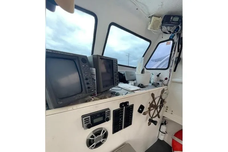 Slide: The Image of 1977 JC 31 Casco Bay boat cockpit with navigation equipment and steering wheel. - 15