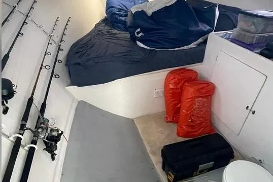 Slide: The Image of Interior of 1977 JC 31 Casco Bay boat with fishing rods and sleeping area. - 19