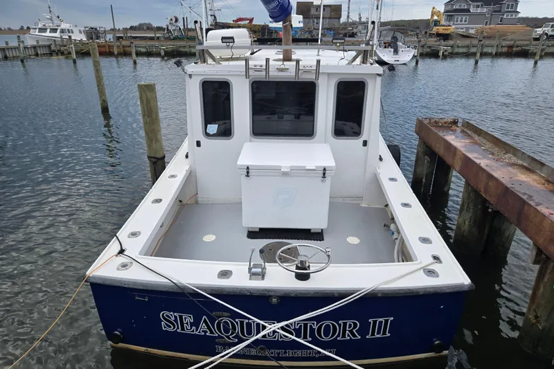 Slide: The Image of 1977 JC 31 Casco Bay boat docked at marina, rear view with open deck. - 2