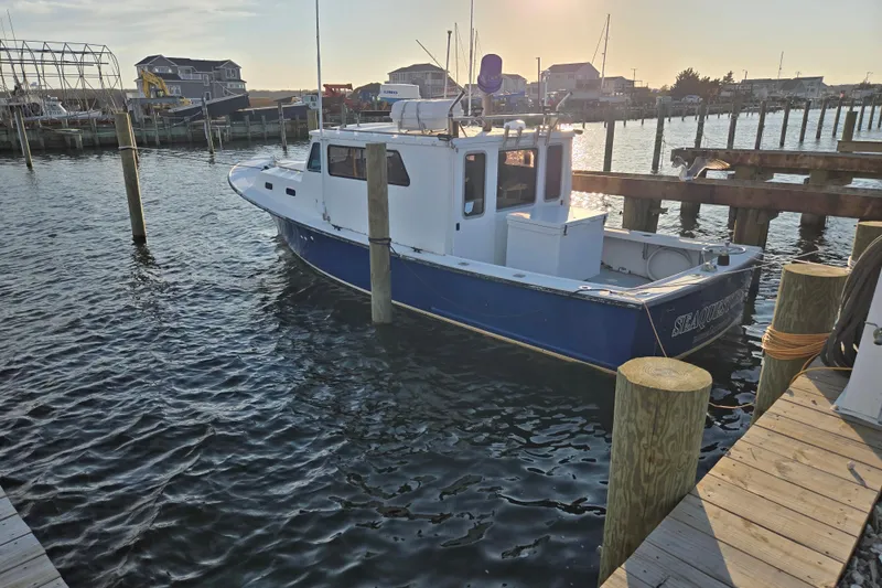 Slide: The Image of 1977 JC 31 Casco Bay boat docked at a marina during sunset. - 22