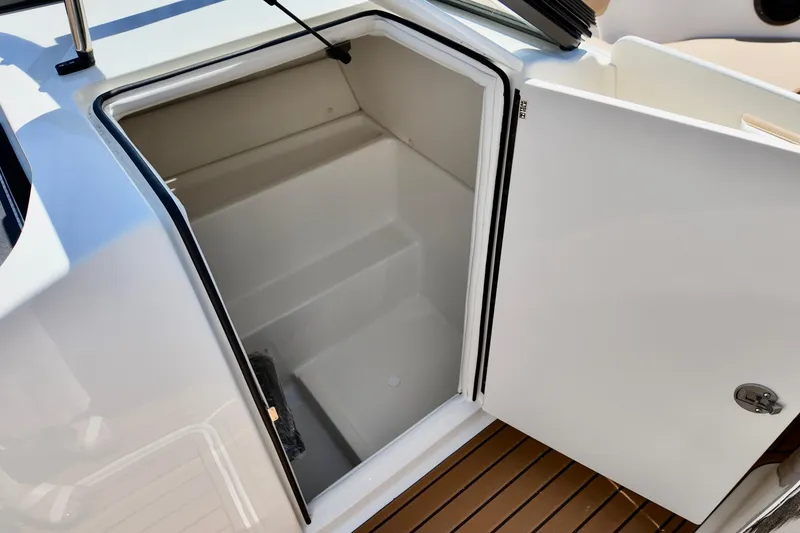 Slide: The Image of 2026 Bayliner VR6 Bowrider OB storage compartment with open door, showcasing interior space. - 13