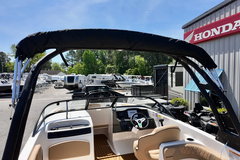 Slide: The Image of 2026 Bayliner VR6 Bowrider OB boat interior at dealership, featuring steering wheel and seating. - 5