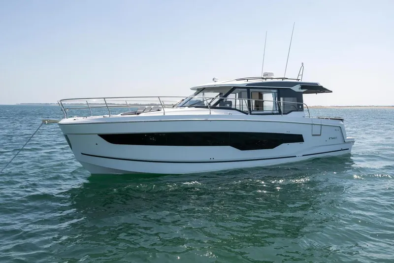 Slide: The Image of Manufacturer Provided Image: 2025 Jeanneau NC 1295 Coupe yacht on calm ocean waters. - 2