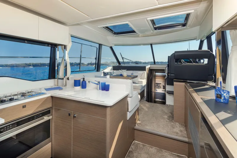 Slide: The Image of Luxurious interior of 2026 Jeanneau NC 1295 Coupe yacht with modern kitchen and seating area. - 8