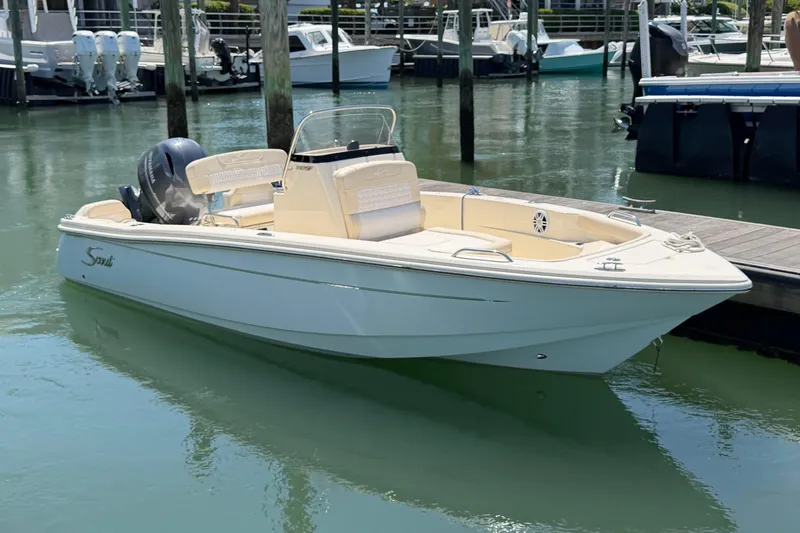 The Image of 2026 Scout 188 Sportfish boat docked in marina, featuring sleek design and modern outboard motor. - 1