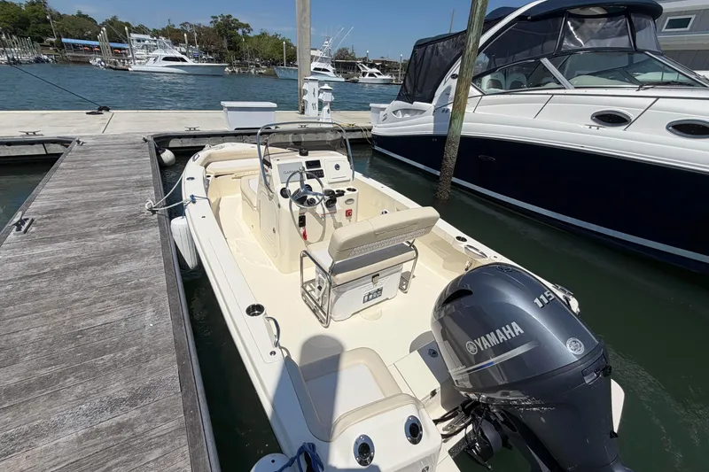 Slide: The Image of 2026 Scout 188 Sportfish boat docked, featuring Yamaha 115 engine, in a marina setting. - 10
