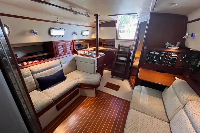 Slide: The Image of Interior of 2000 Island Packet 350 sailboat with cozy seating and wooden finishes. - 10