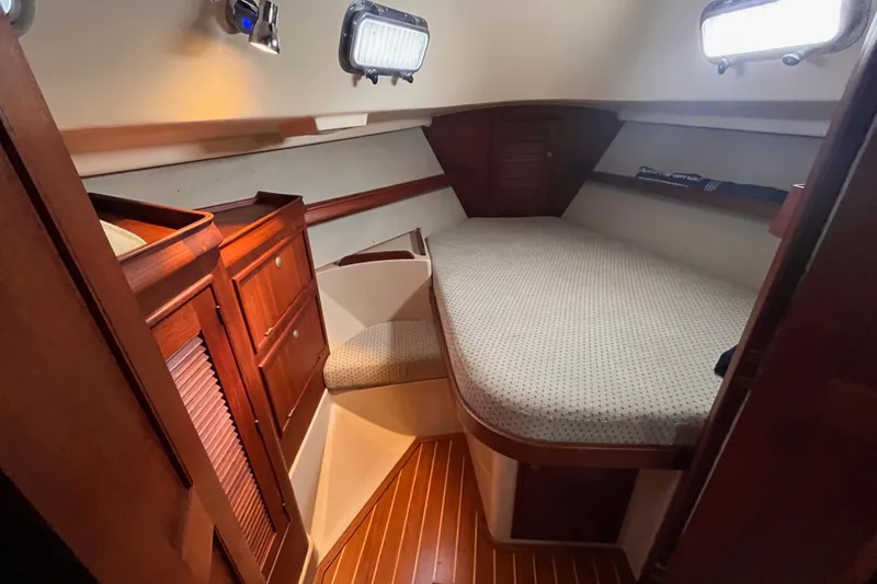 Slide: The Image of Cozy cabin interior of 2000 Island Packet 350 sailboat with wooden cabinetry and bed. - 11