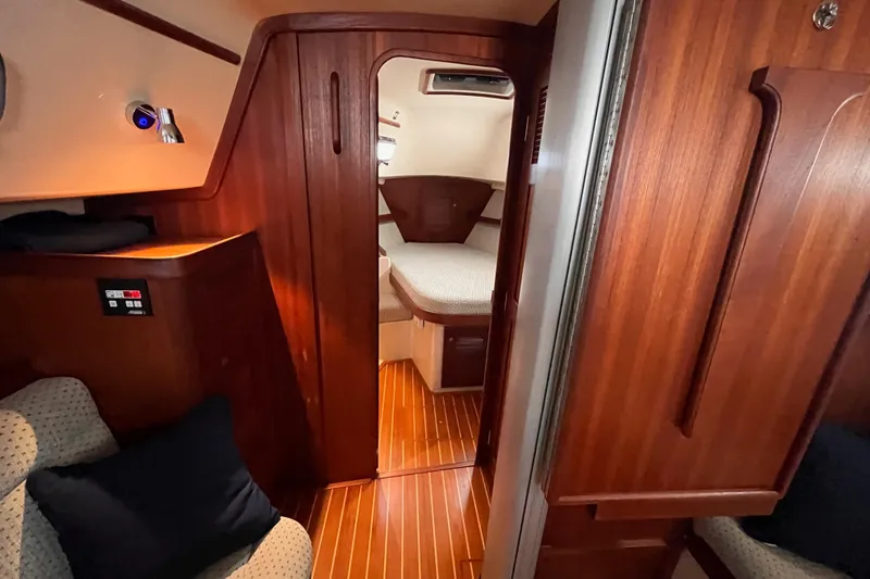 Slide: The Image of Interior of 2000 Island Packet 350 sailboat with cozy wooden cabin and seating area. - 12
