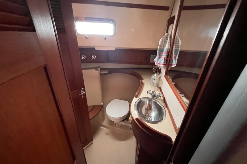 Slide: The Image of Island Packet 350 yacht bathroom, featuring wooden cabinetry and stainless steel sink, 2000 model. - 13