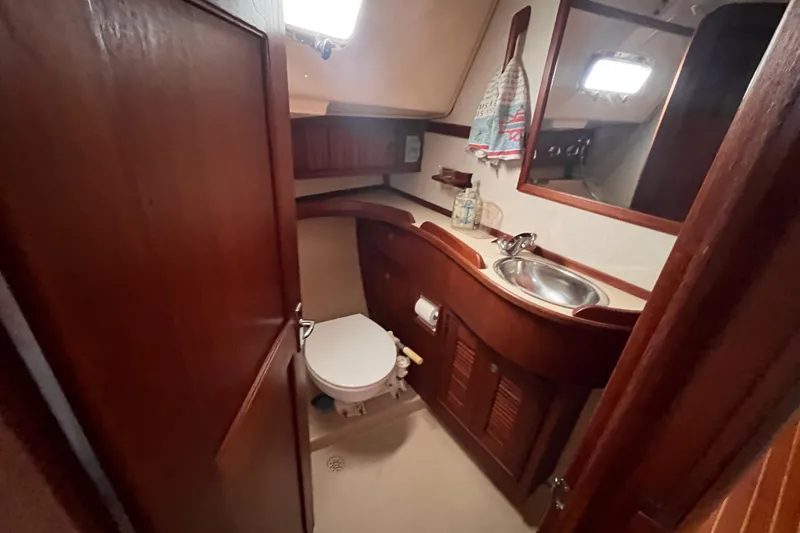 Slide: The Image of Interior of 2000 Island Packet 350 yacht bathroom with wooden cabinetry and stainless steel sink. - 14