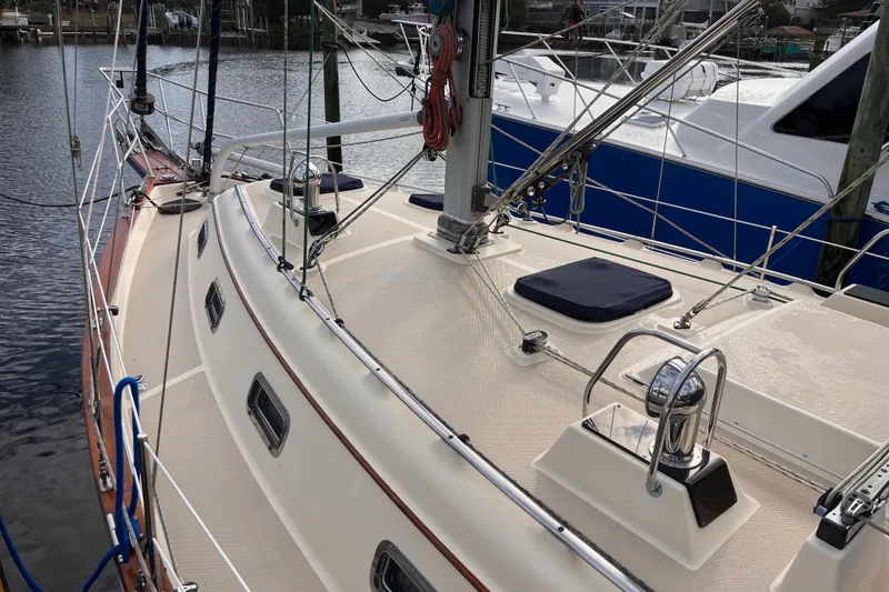 Slide: The Image of 2000 Island Packet 350 sailboat deck with rigging and winches, docked in a marina. - 3