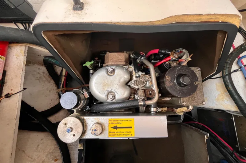 Slide: The Image of Engine compartment of a 2000 Island Packet 350 sailboat, showing mechanical components and wiring. - 33
