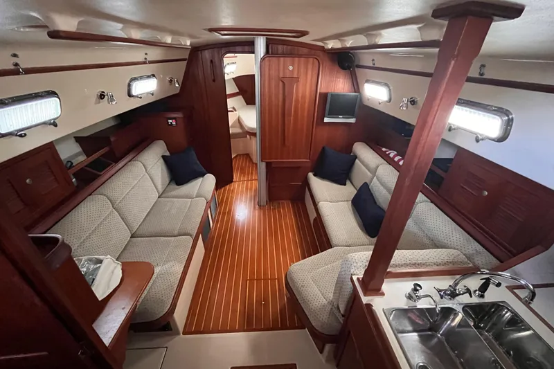 Slide: The Image of Interior of a 2000 Island Packet 350 sailboat with cozy seating and wooden finishes. - 5
