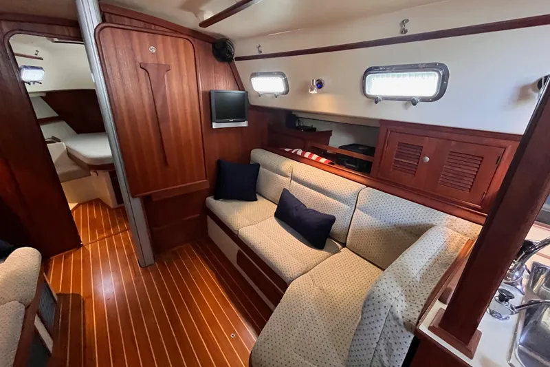 Slide: The Image of Interior of 2000 Island Packet 350 sailboat with cozy seating and wooden finishes. - 9