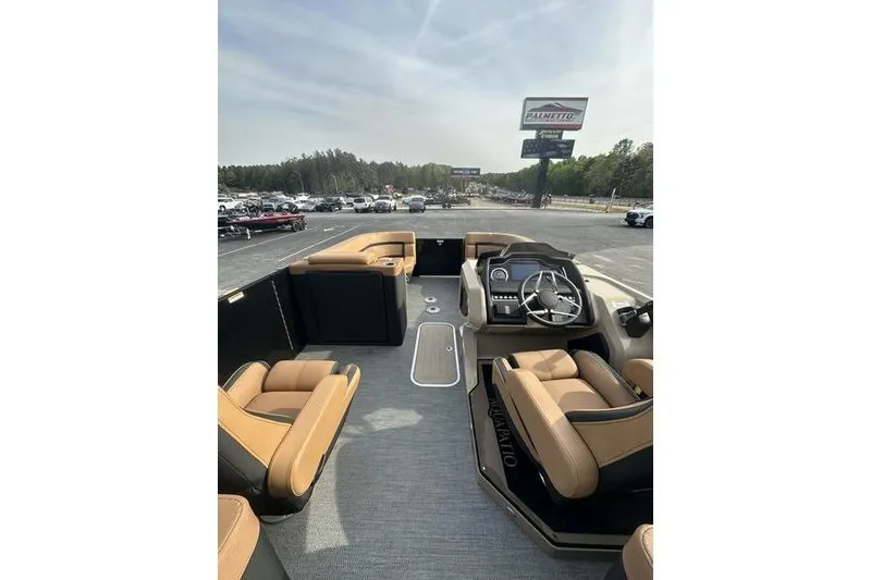 Slide: The Image of 2024 Godfrey AquaPatio 235 ULC iMPACT pontoon boat interior with tan seating and steering console. - 16