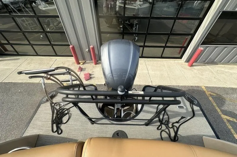 Slide: The Image of 2024 Godfrey AquaPatio 235 ULC iMPACT boat with outboard motor, docked near a garage. - 17