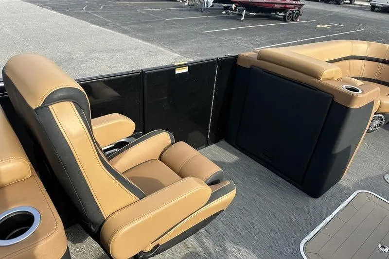 Slide: The Image of 2024 Godfrey AquaPatio 235 ULC boat interior with tan and black seating. - 18