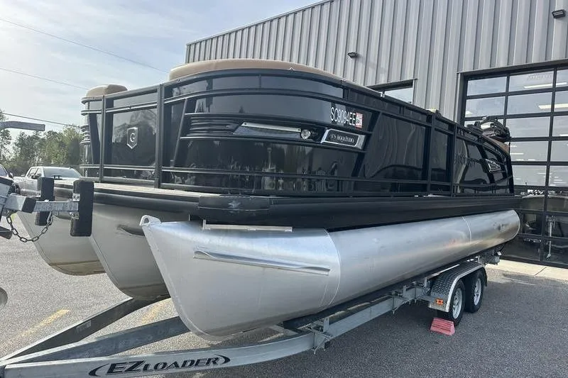 Slide: The Image of 2024 Godfrey AquaPatio 235 ULC pontoon boat on trailer outside a building. - 3