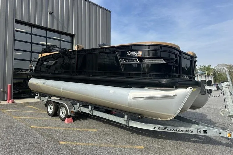 Slide: The Image of 2024 Godfrey AquaPatio 235 ULC pontoon boat on trailer outside a warehouse. - 4