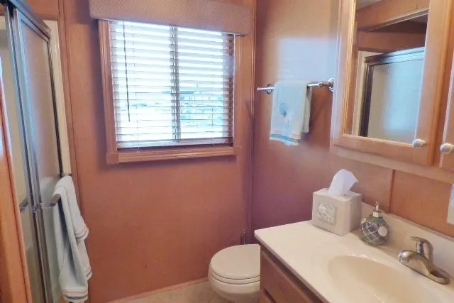 Slide: The Image of Compact bathroom with wooden accents, featuring a window, sink, and shower in a 2007 Starlite 18x85. - 10