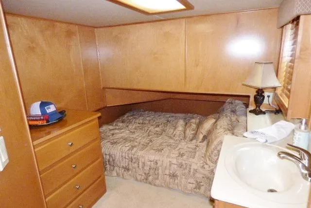 Slide: The Image of Cozy bedroom in 2007 Starlite 18x85 houseboat with wooden furnishings and compact sink. - 6