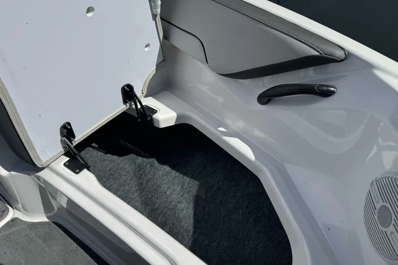 Slide: The Image of 2024 Yamaha AR190 boat interior storage compartment with open hatch and carpeted flooring. - 27