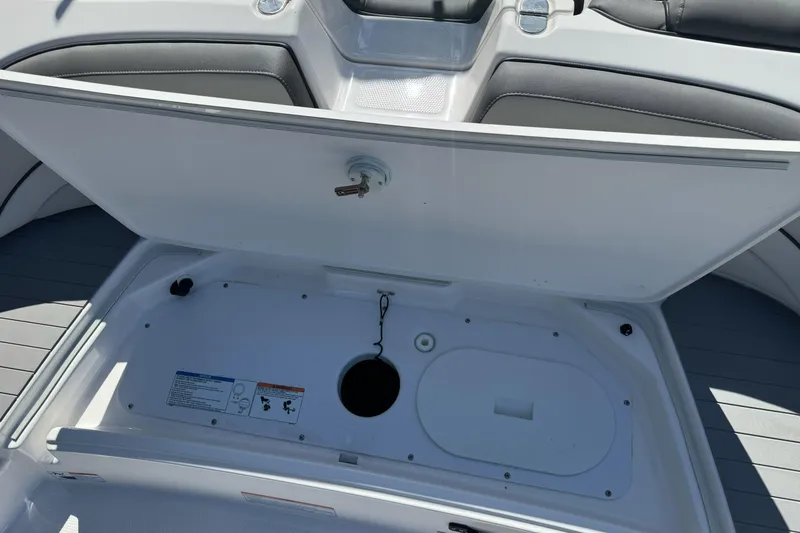 Slide: The Image of 2024 Yamaha AR190 boat storage compartment with open lid, showcasing interior space. - 32