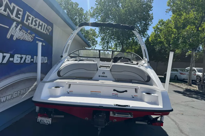 Slide: The Image of 2024 Yamaha Boats AR190 displayed outdoors, rear view, near a marine dealership. - 4
