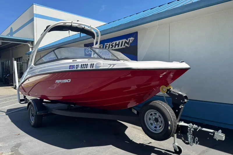 Slide: The Image of 2024 Yamaha Boats AR190 in red, parked on a trailer outside a building. - 7