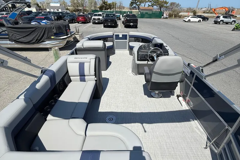 Slide: The Image of 2026 Berkshire 22CL2 CTS pontoon boat interior with seating and steering console in a parking lot. - 11