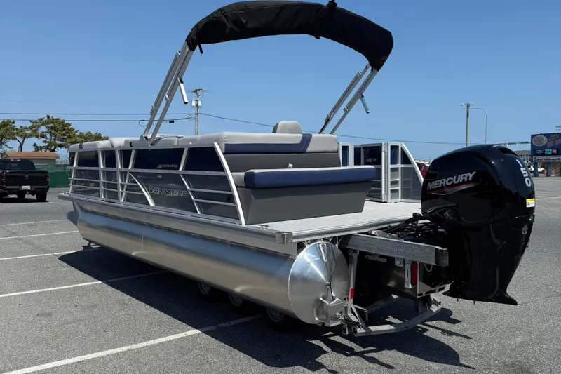 Slide: The Image of 2026 Berkshire 22CL2 CTS pontoon boat with Mercury outboard motor in a parking lot. - 6