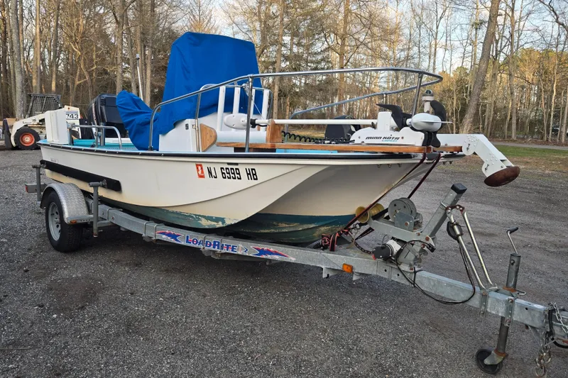 The Image of 1972 Boston Whaler 17 Montauk boat on trailer, parked outdoors with blue cover. - 0