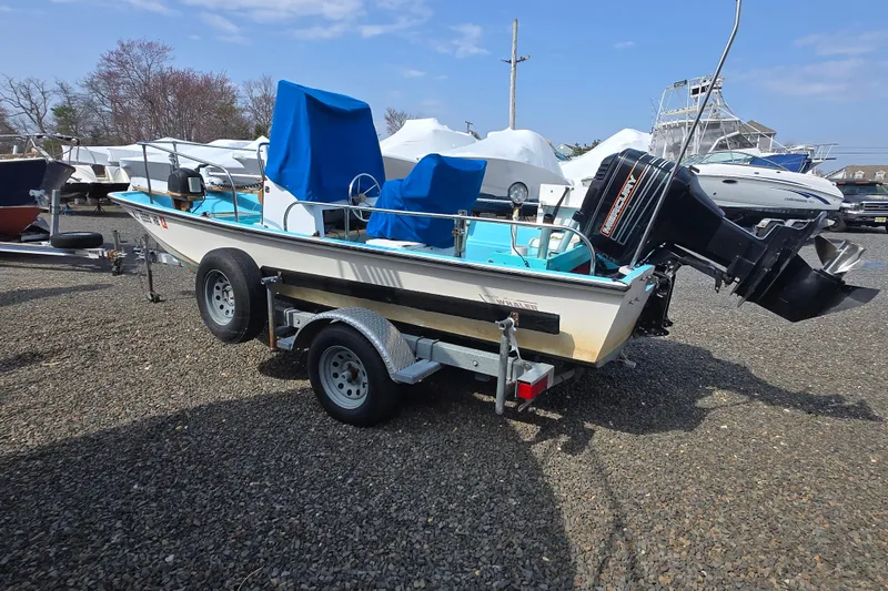Slide: The Image of 1972 Boston Whaler 17 Montauk boat on trailer, covered seats, outboard motor, outdoor setting. - 10