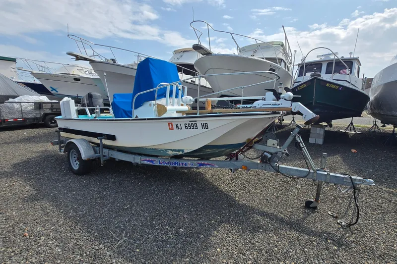 Slide: The Image of 1972 Boston Whaler 17 Montauk boat on trailer in a marina. - 11