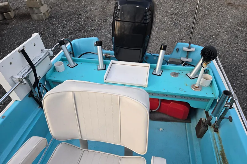Slide: The Image of 1972 Boston Whaler 17 Montauk boat interior with white seating and fishing rod holders. - 18