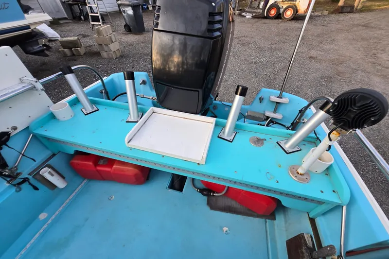 Slide: The Image of 1972 Boston Whaler 17 Montauk boat interior with fishing rod holders and engine. - 19