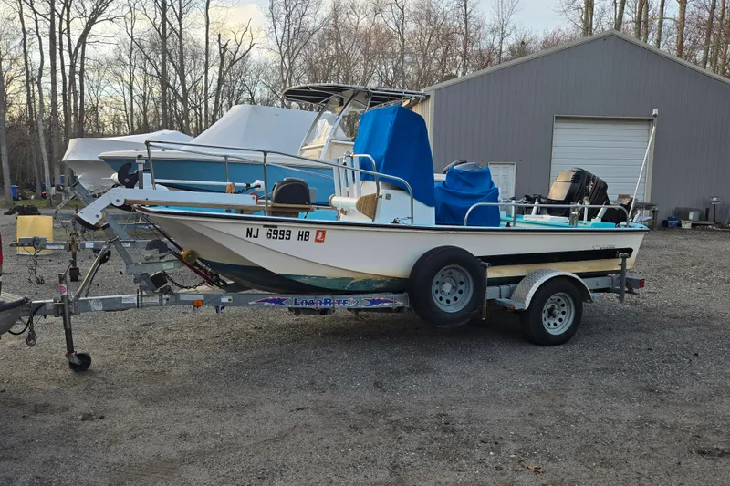 Slide: The Image of 1972 Boston Whaler 17 Montauk boat on trailer, parked near a garage. - 22